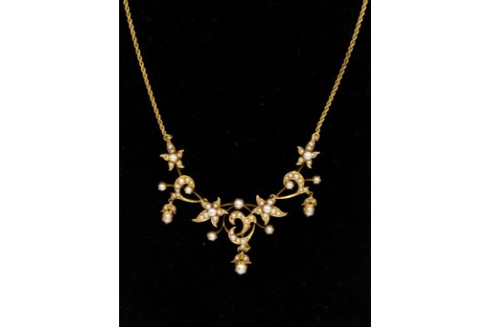 An Edwardian seed pearl and gold necklace, comprising an articulated front  of pearl set flower