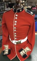 A vintage Coldstream Guard tunic and Kings Crown belt. Red wool body, with dark blue facings and