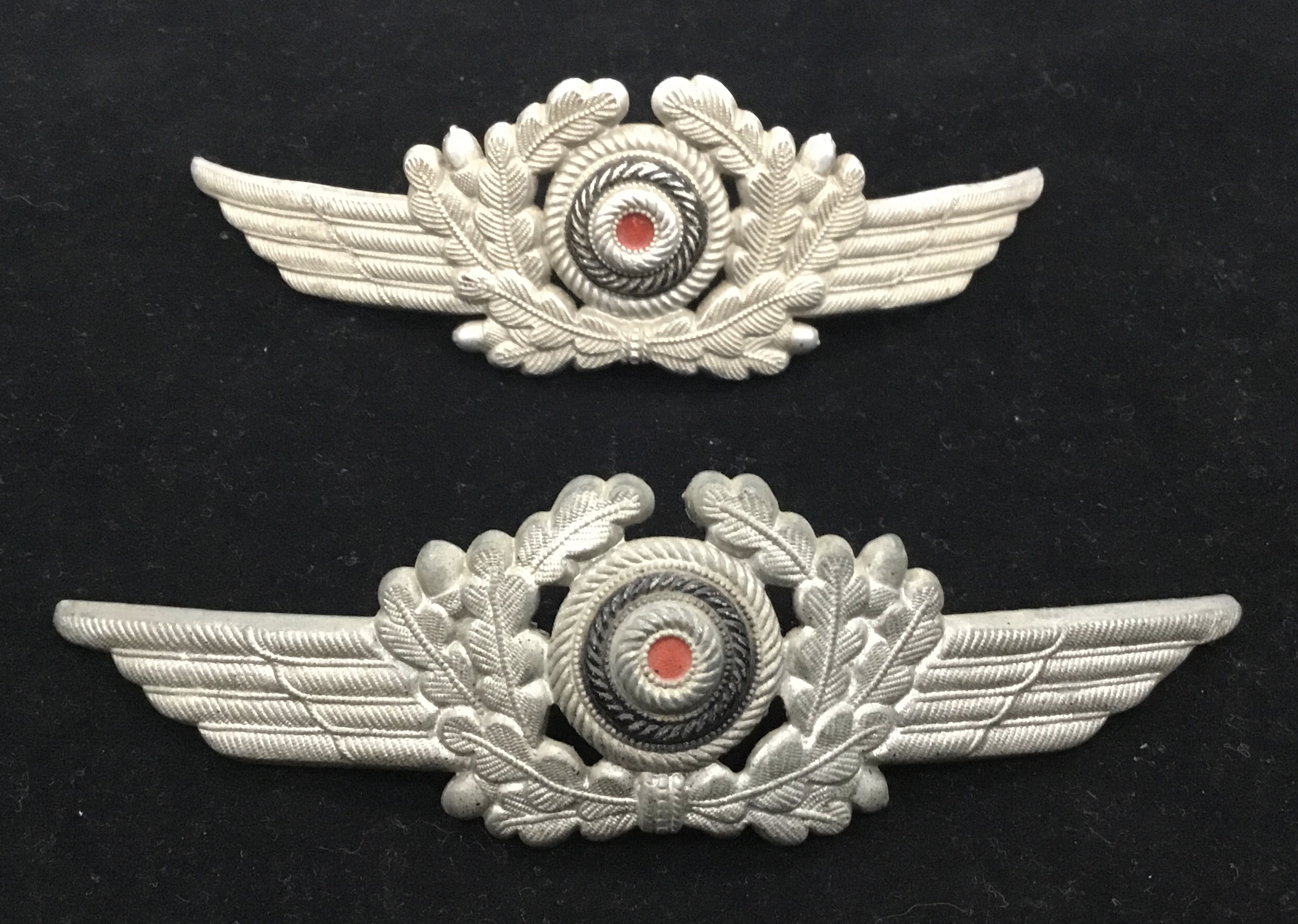2 Ww2 Luftwaffe officers metal visor badges. Both with painted cockade area, flanked by die