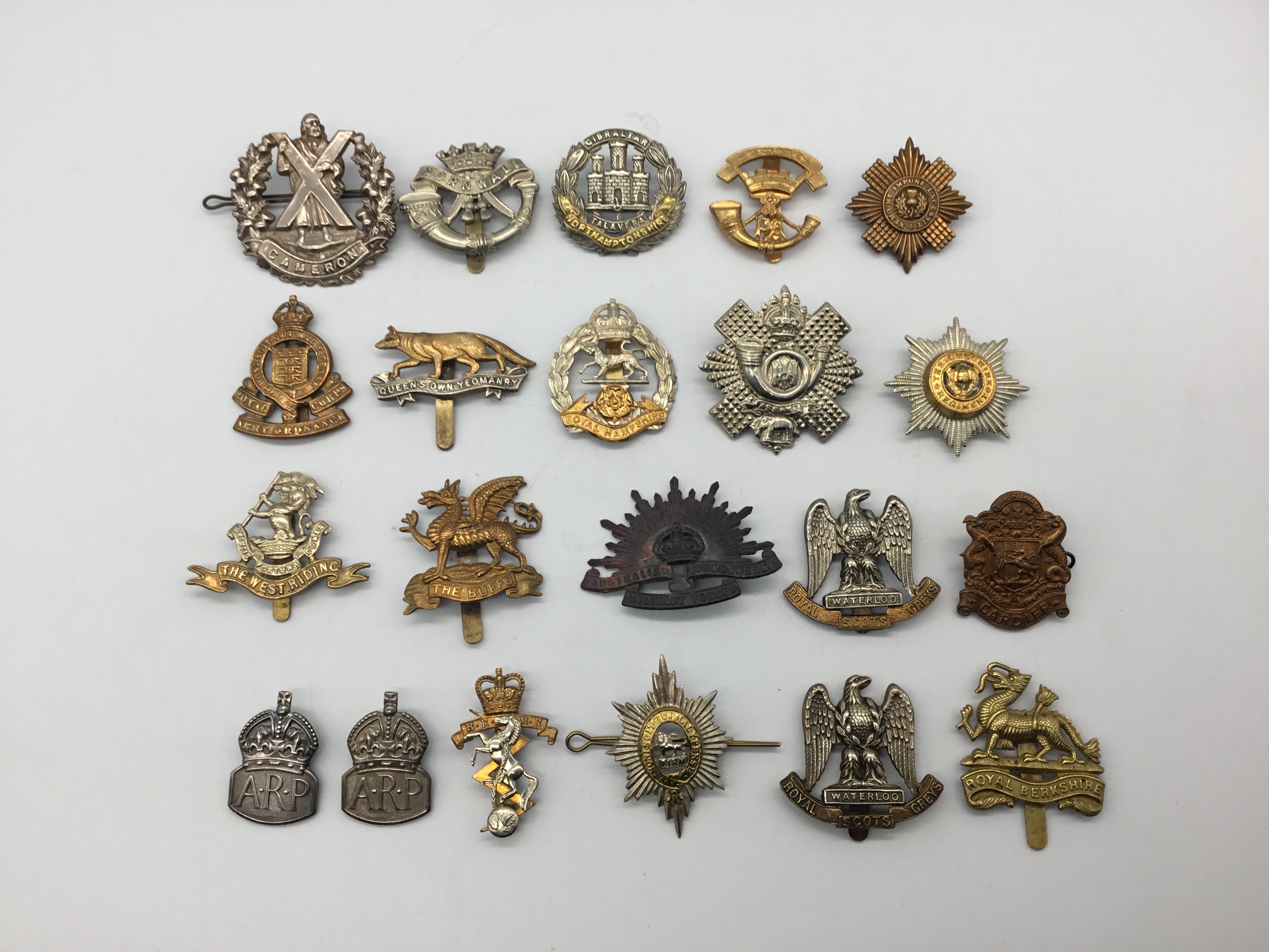 A quantity of WW1, WW2 and later British regimental cap badges, plus some sterling silver WW2 ARP