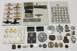 A selection of various military badges, and other items. To include: a board containing modern cap