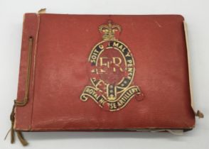 A mid 20th century Royal Horse Artillery photograph album. Red faux reptile skin cover, with black