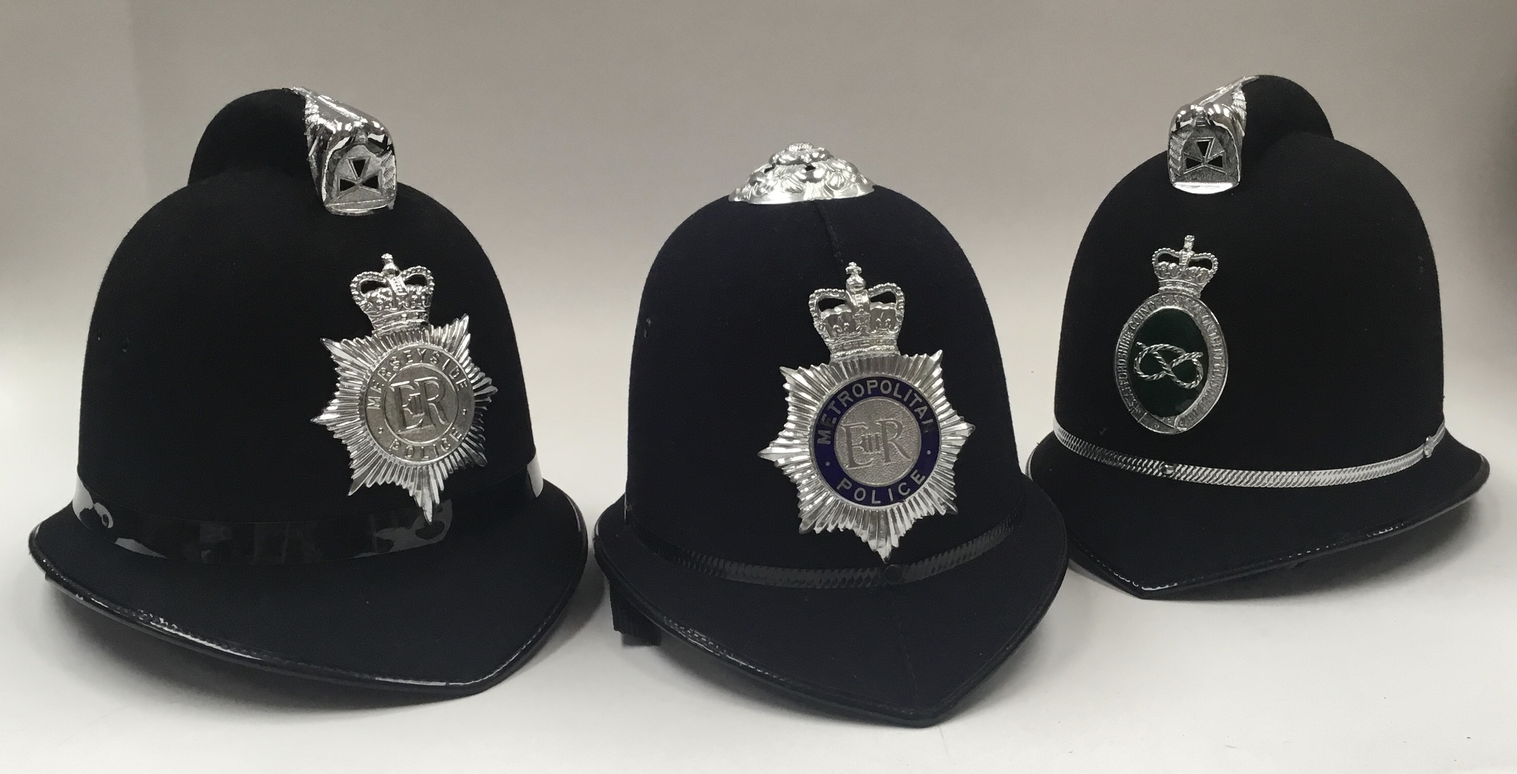 3 vintage British Police helmets, each with chromed badges applied to the fronts. To include: a