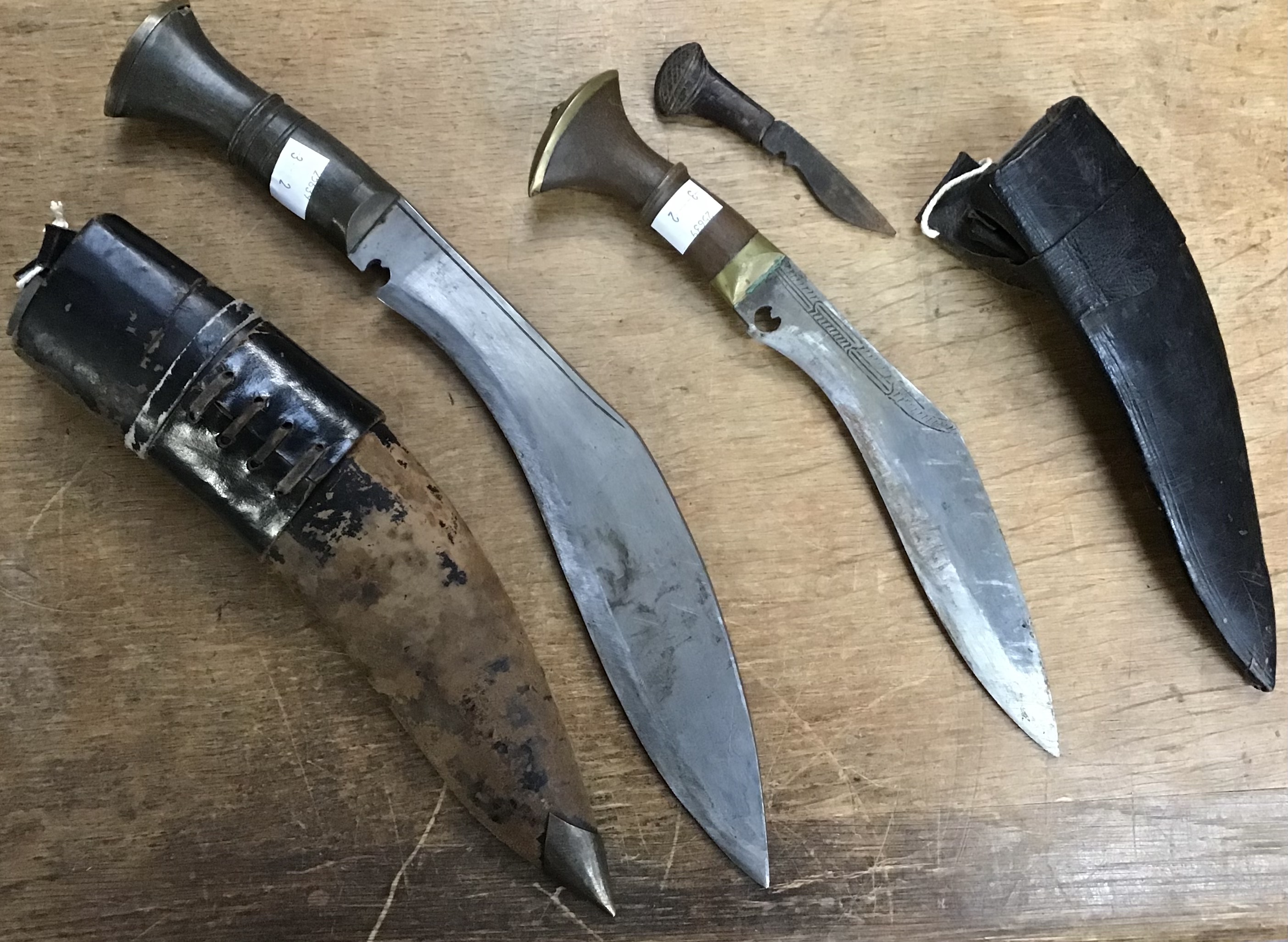 A pair of post war Kukri knifes both with scabbards the larger is 39cm the smaller 30cm, both with