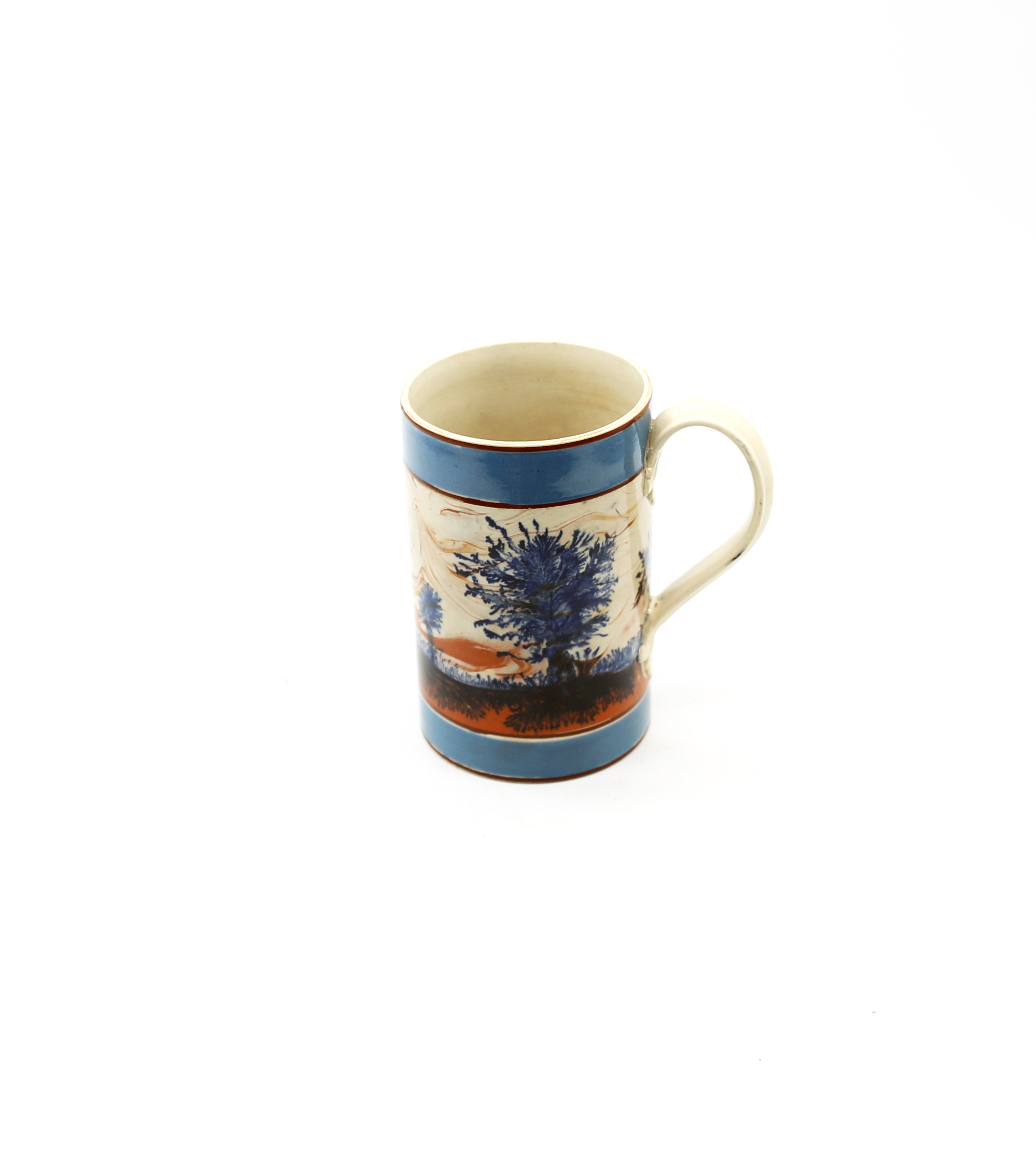 A mocha cylindrical mug, with blue feathered blue trees and a tan and black landscape and wide
