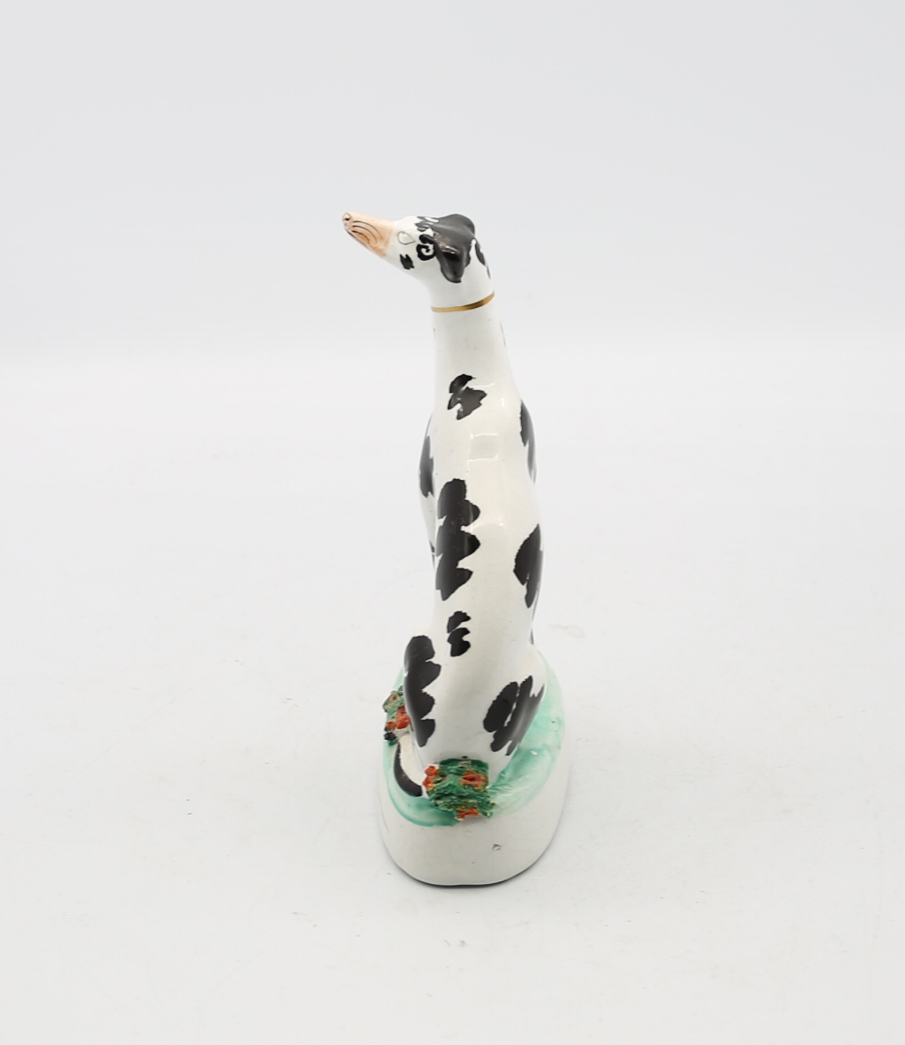 A Staffordshire potter model of a seated black and white Dalmatian on a green oval base.  Circa - Image 2 of 5