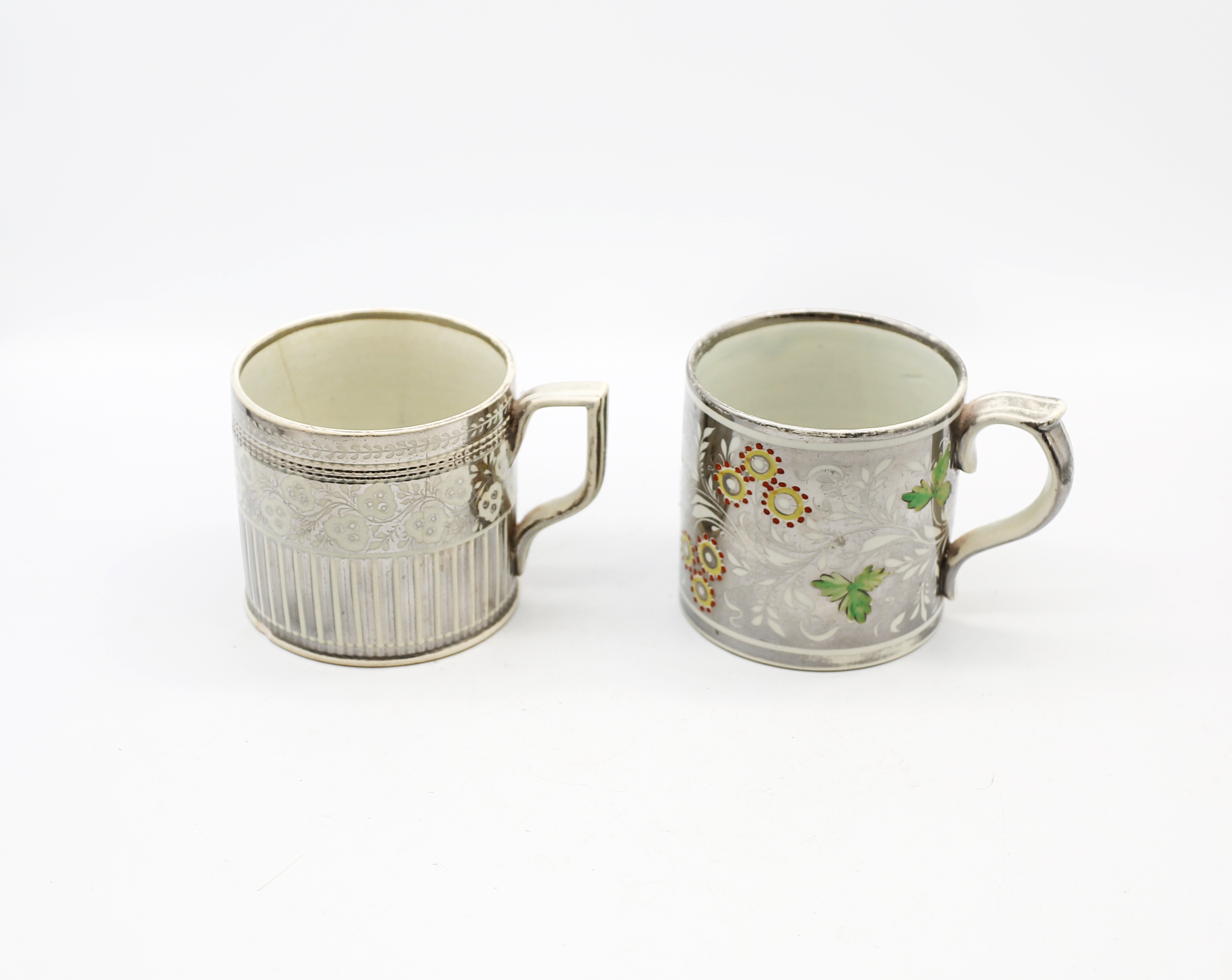 Two silver lustre mugs. One with yellow flowers and green leaves and an engine turned mug with