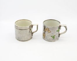 Two silver lustre mugs. One with yellow flowers and green leaves and an engine turned mug with