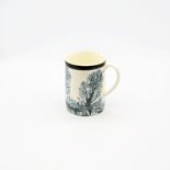 A  creamware Mocha mug, cream ground with blue/grey feathered trees, with a black band to the top