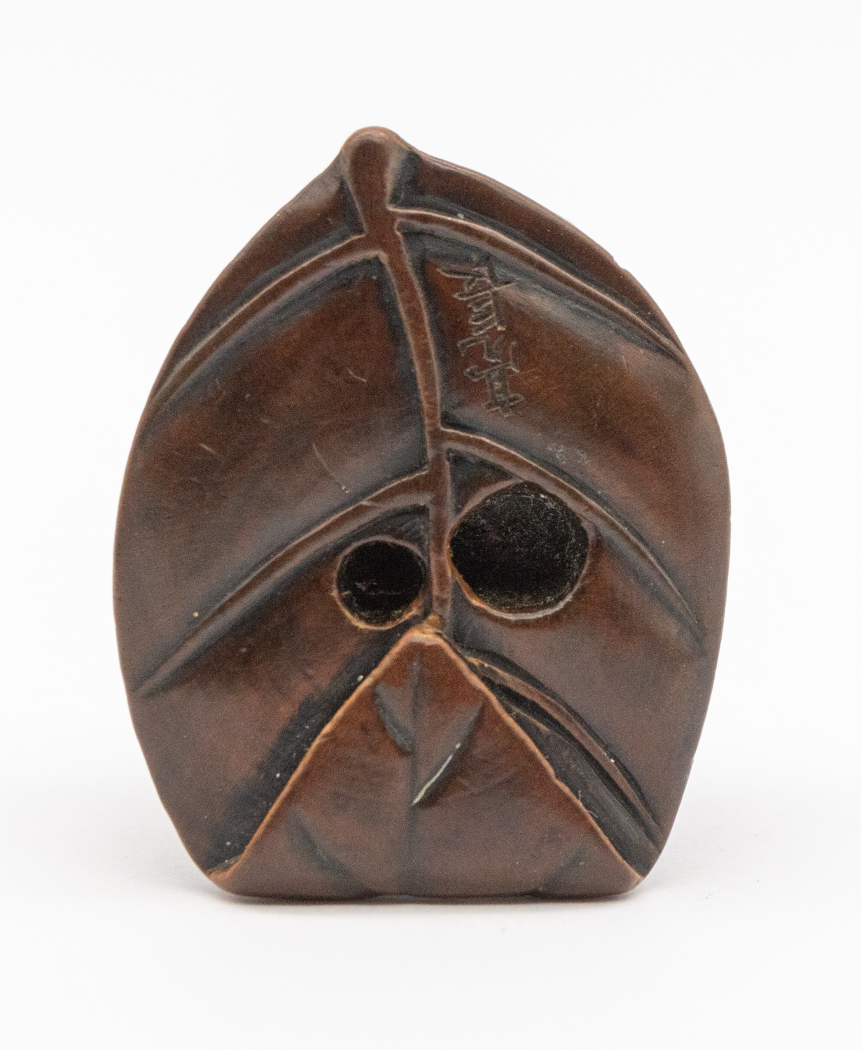 A 19th century Japanese wooden frog netsuke, perching on a leaf with orange eyes, signed underneath, - Bild 4 aus 5