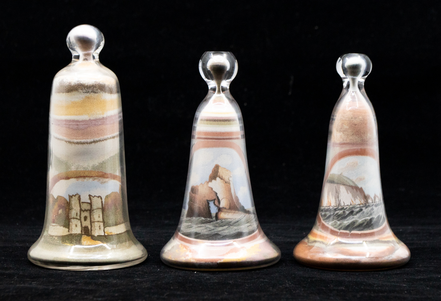 Three early 20th Century Isle of Wight curiosity sand sculptures in bottles, labels to base.