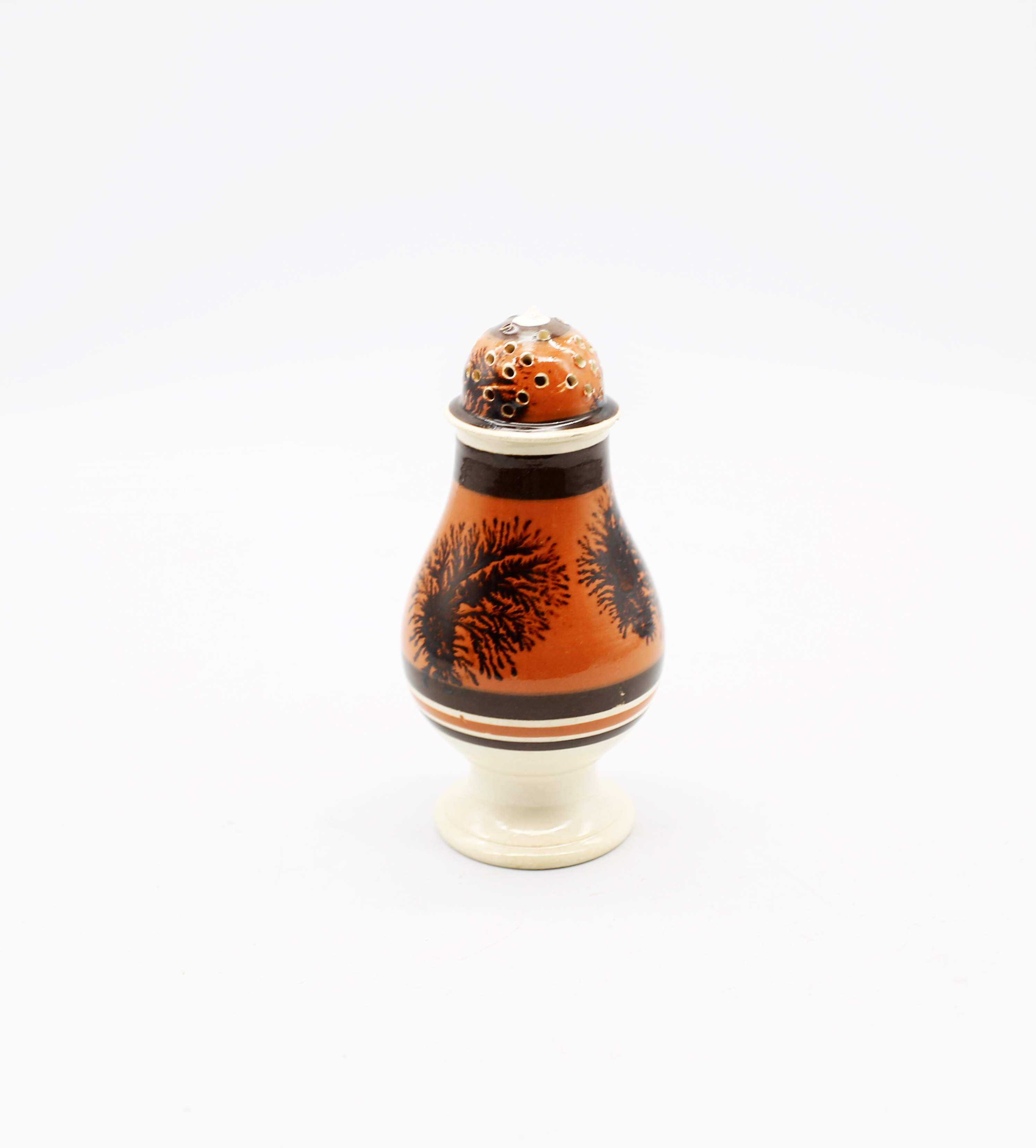 A creamware Mocha caster, dark orange ground, with brown feathered trees and bands.  Circa 1800-
