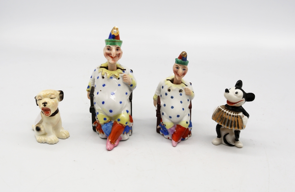 Two porcelain figurines of Mr Punch, both with nodding heads, with mixed speckled clothing and hats,