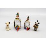 Two porcelain figurines of Mr Punch, both with nodding heads, with mixed speckled clothing and hats,