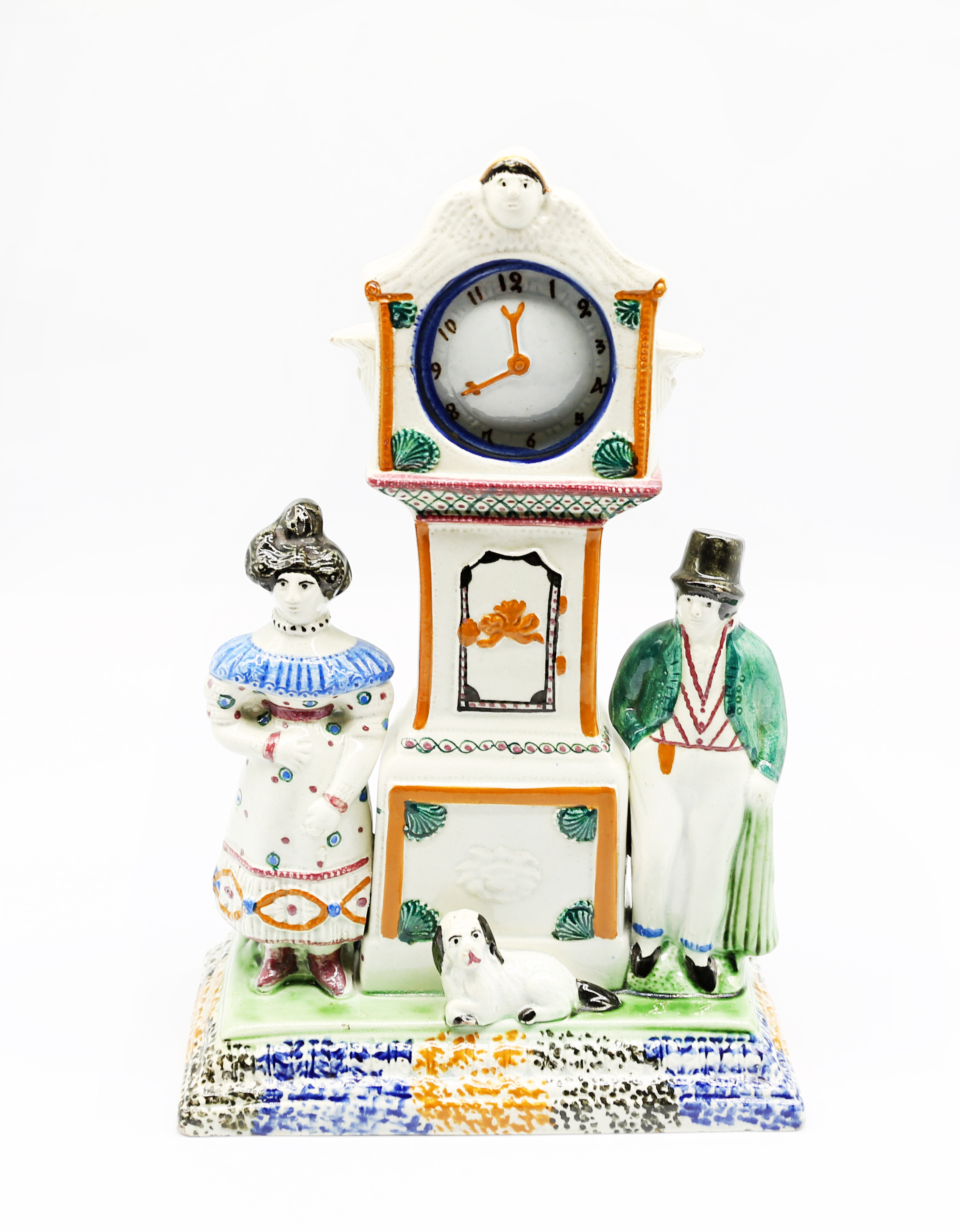 A Prattware watch stand and watch.  Flanked by a man and a woman and a dog. Complete with original