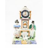 A Prattware watch stand and watch.  Flanked by a man and a woman and a dog. Complete with original