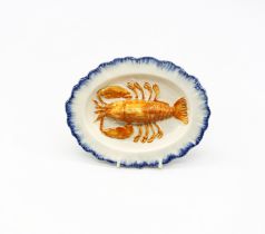 A pearlware ‘Toy’ oval platter with a lobster moulded to the centre with a blue feathered border.