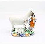 A Prattware model of a sheep and her lambs laying beneath her, with a shepherdess standing to the