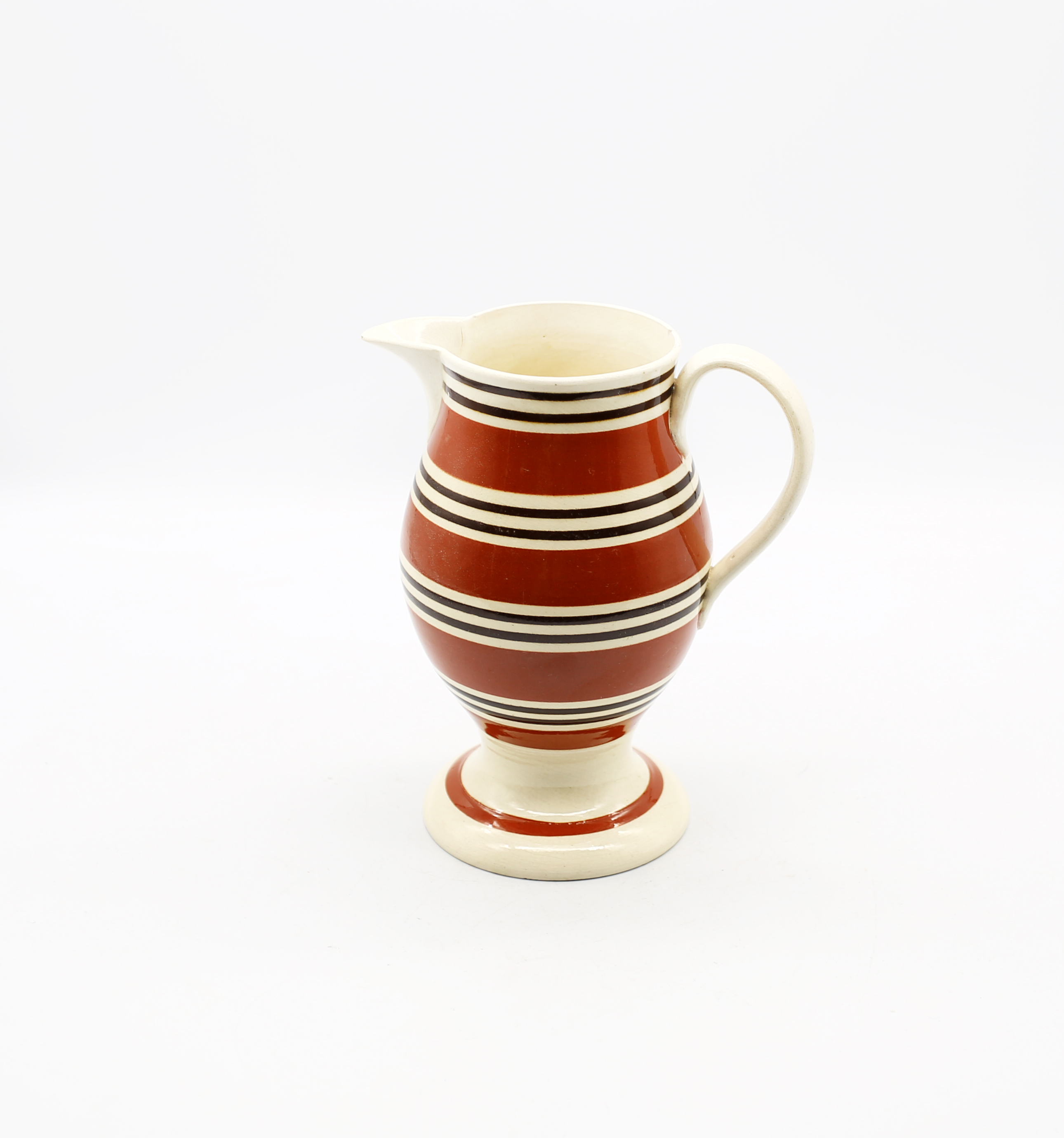 A creamware pedestal jug, with wide dark orange bands and narrow black bands  Circa 1800-1820. Size.