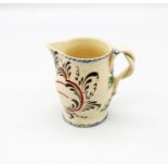 A small Leeds creamware jug with a plough painted in red and black with blue feathered rims and