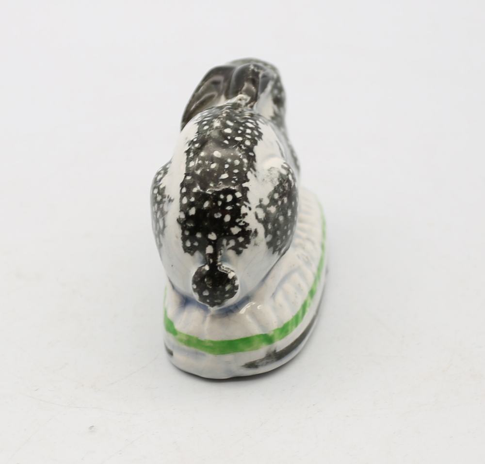 A Staffordshire pottery Rabbit crouched on an oval base, black sponged markings,  with green and - Image 4 of 5