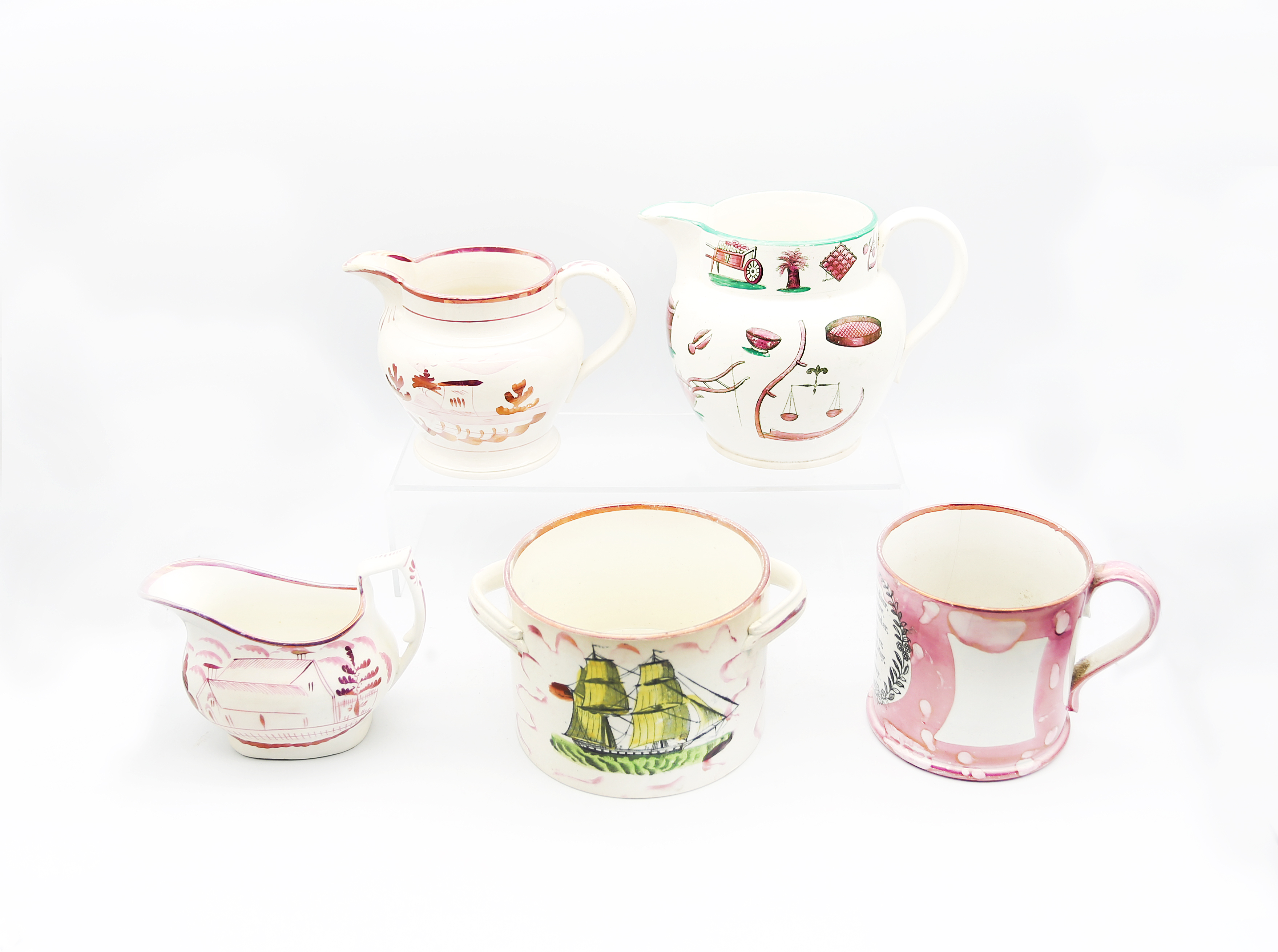 A small collection of pink lustre creamware, including, a twin handled pot, a mug, two jugs and a