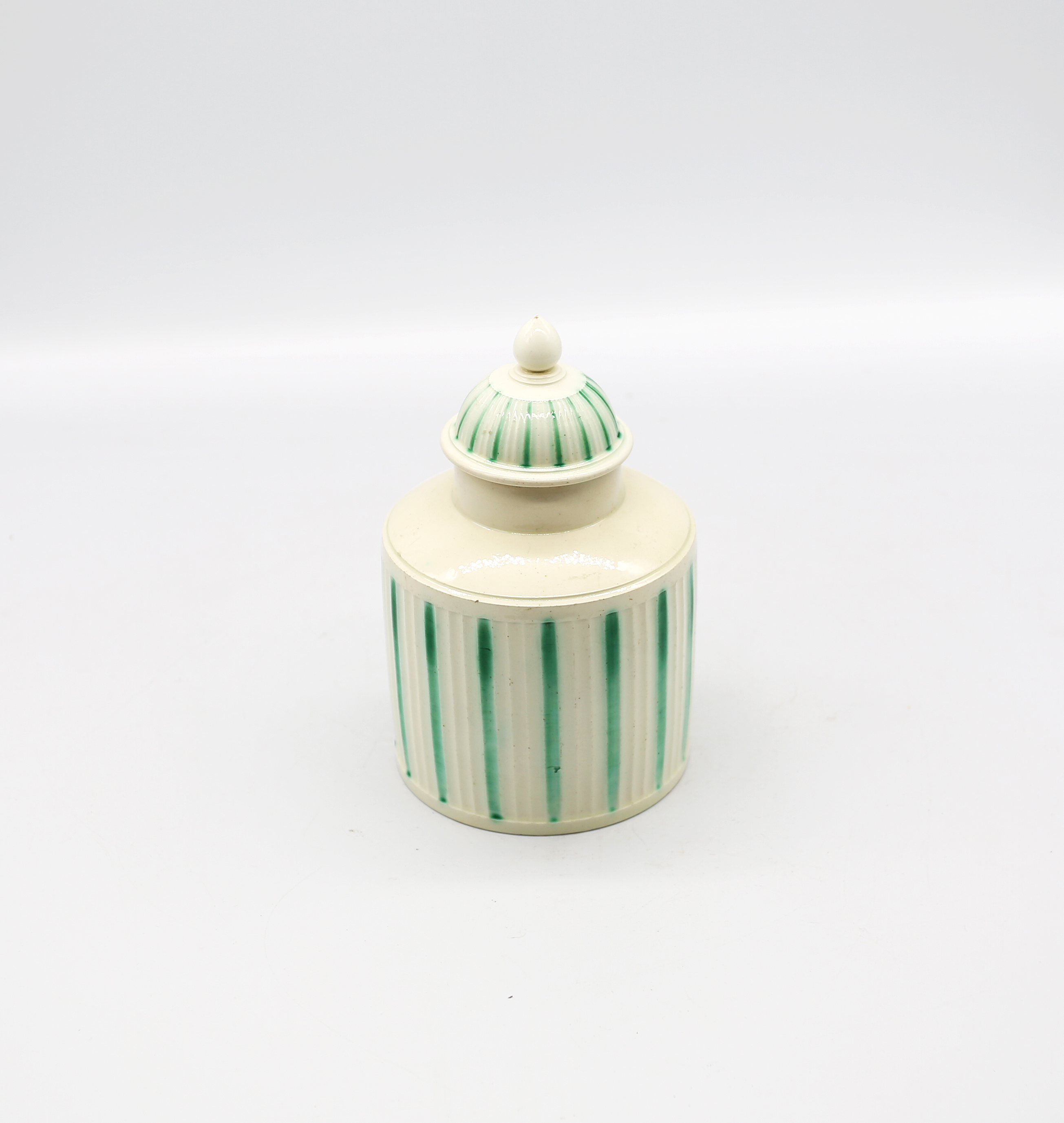 A Leeds creamware tea caddy and cover, with a ribbed body decorated  with green stripes  Circa 1775.