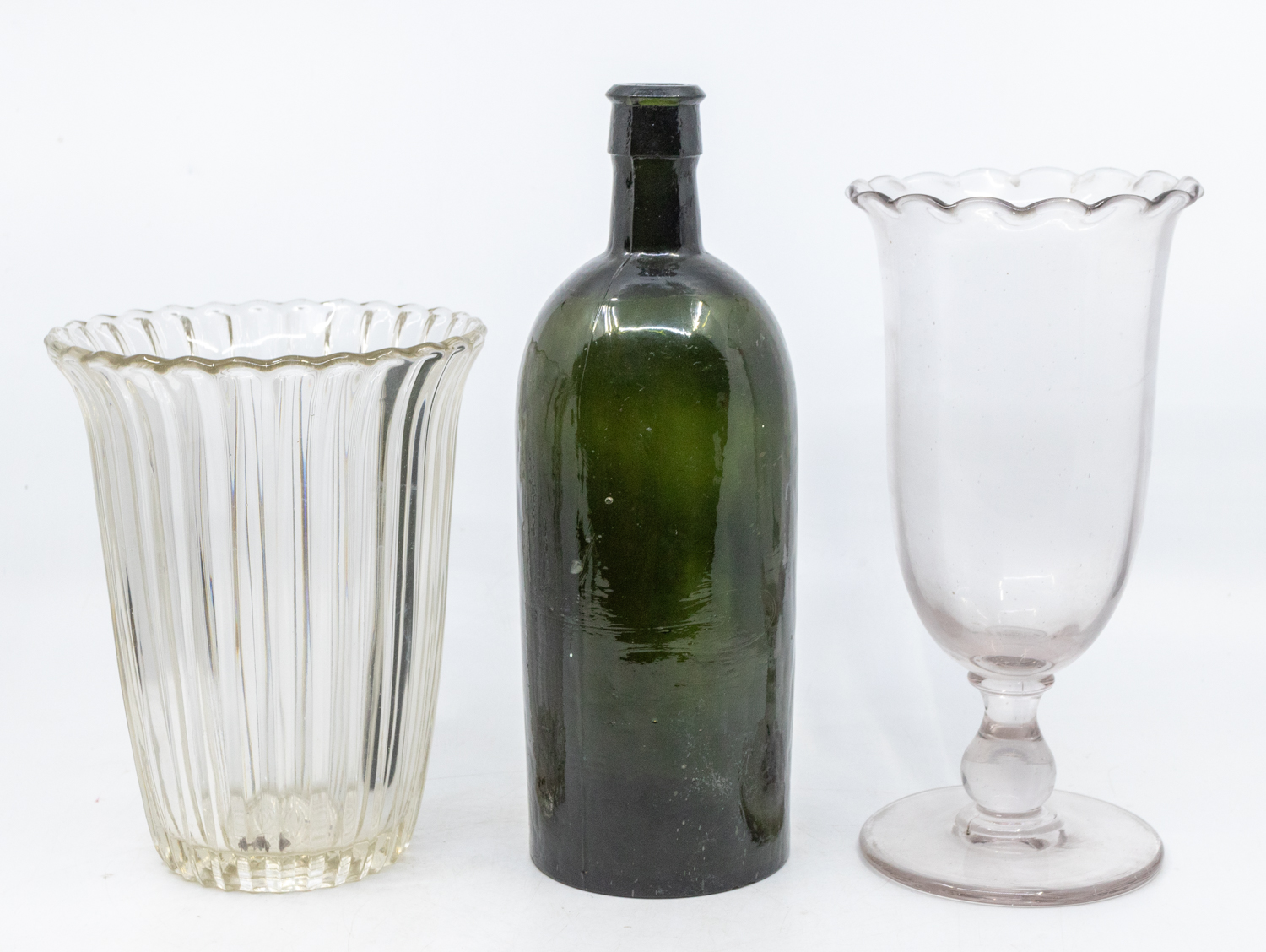An 18th Century green glass rum bottle, an early 19th Century fluted vase and a Victorian celery