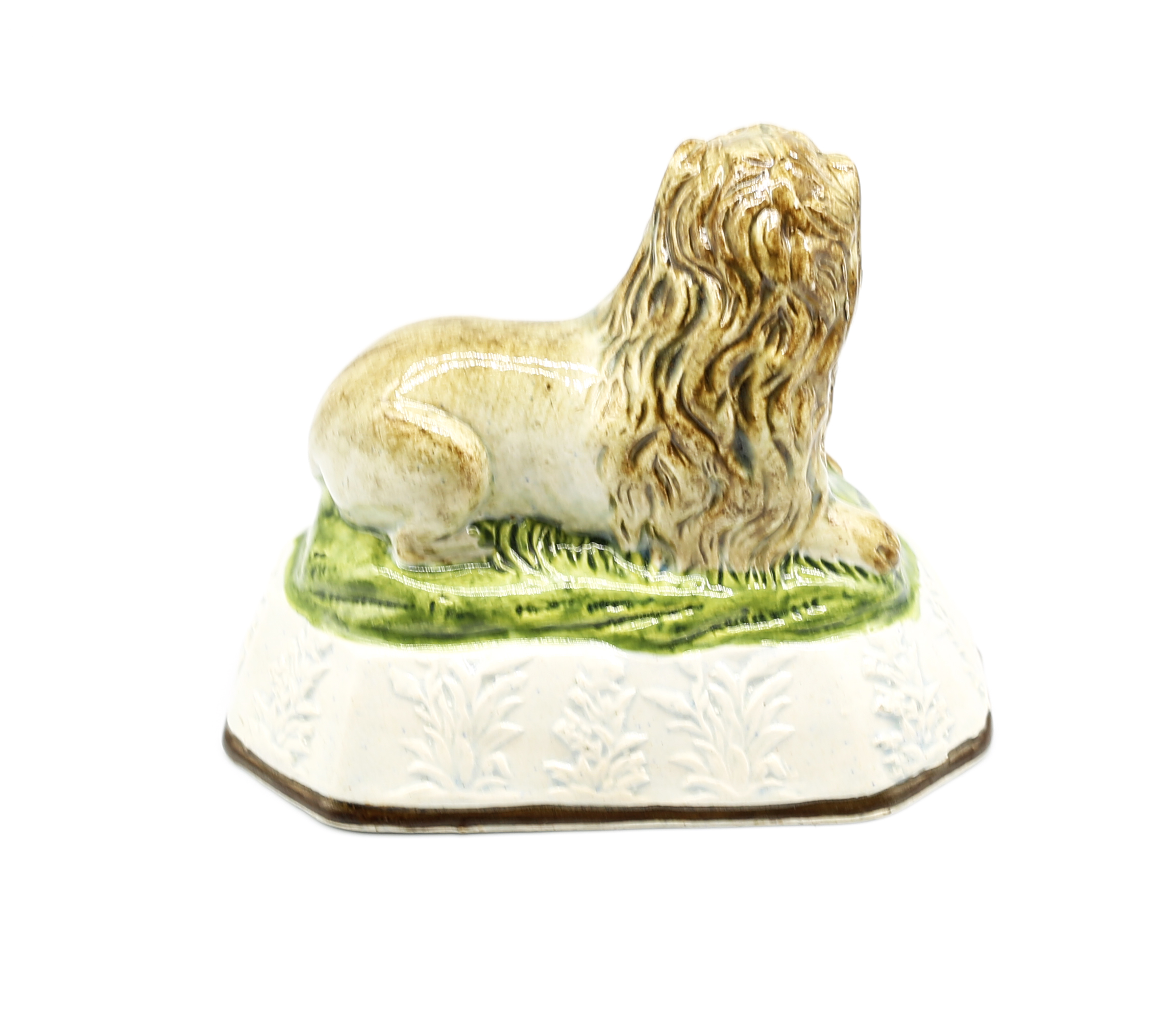 A pearlware model of a recumbent lion laying on a grassy mound on a base with moulded relief.  Circa - Image 3 of 8