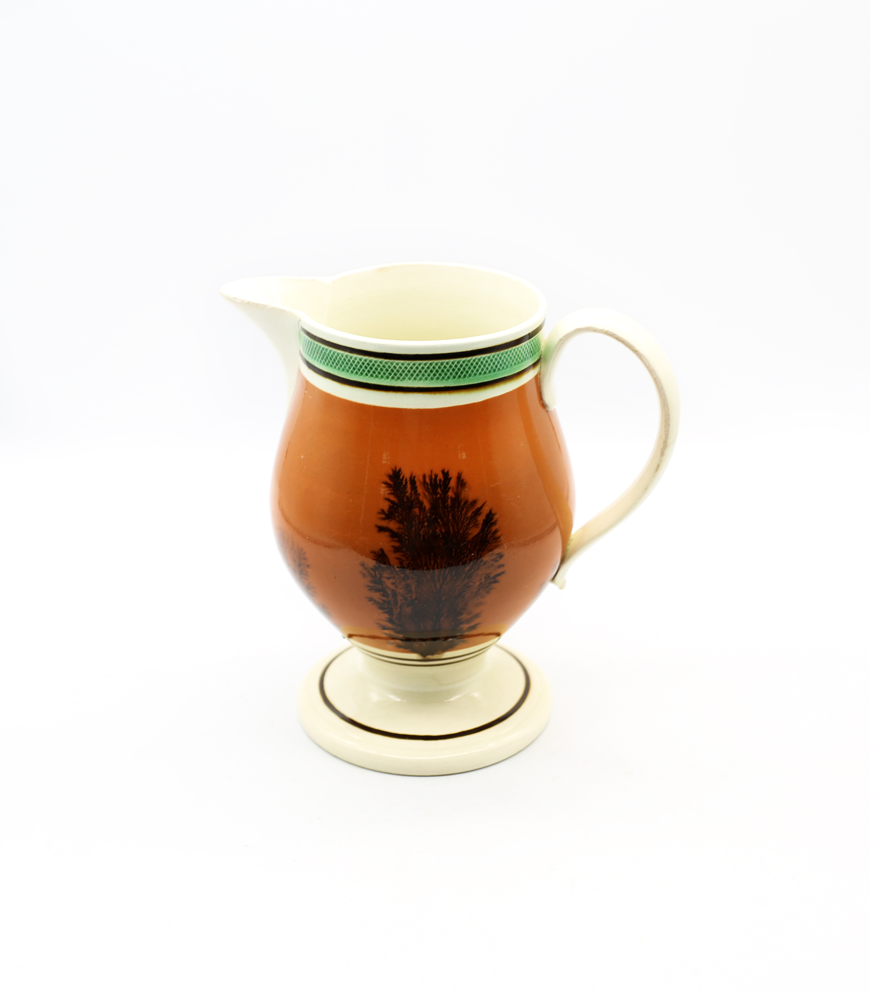 A creamware Mocha footed jug, dark terracotta with black feathered trees and green and brown