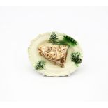 A creamware ‘Toy’ oval platter with a Salmon head moulded to the centre. With green sprigs to the