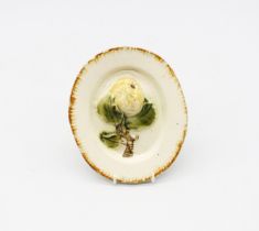 A creamware ‘Toy’ oval platter with an apple and foliage moulded in the centre, with an ochre