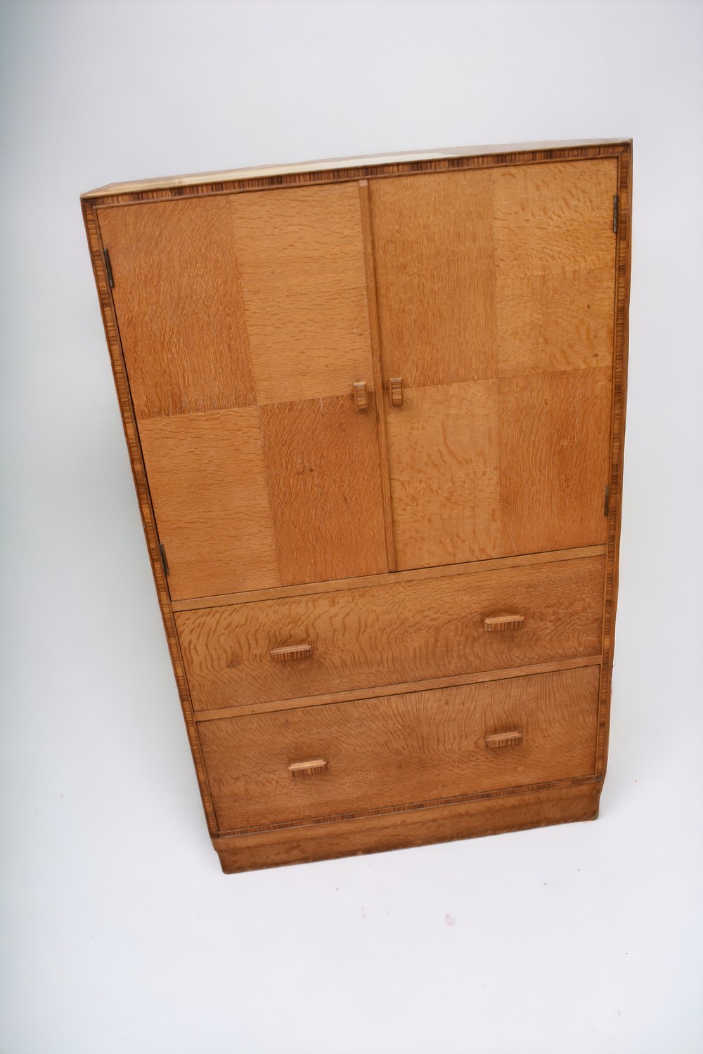 A Heal's cabinet of two cupboards above two drawers, with patchwork design and banded detail