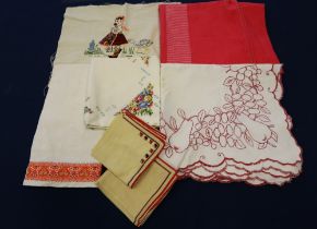 A collection of colourful tablecloths and embroidered clothes from the 1930s, 1940s and 1950s,