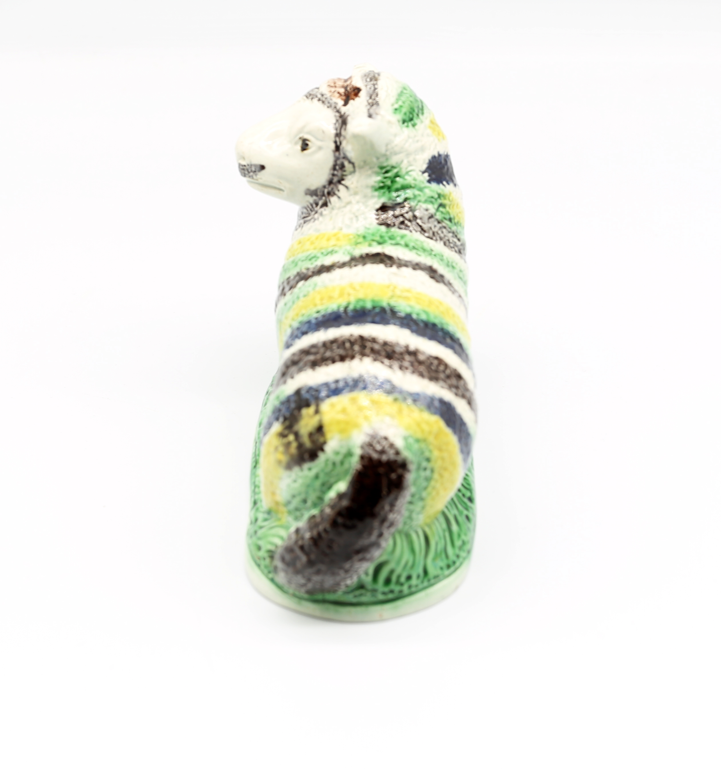 A pottery model of a recumbent Ewe, decorated with green, yellow and black stripes.  Circa 1800- - Image 4 of 7