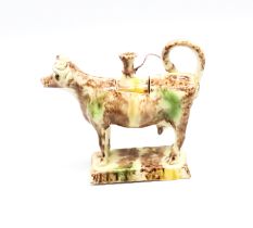 A Staffordshire Whieldon creamware cow creamer standing on an oblong base, sponge decorated in