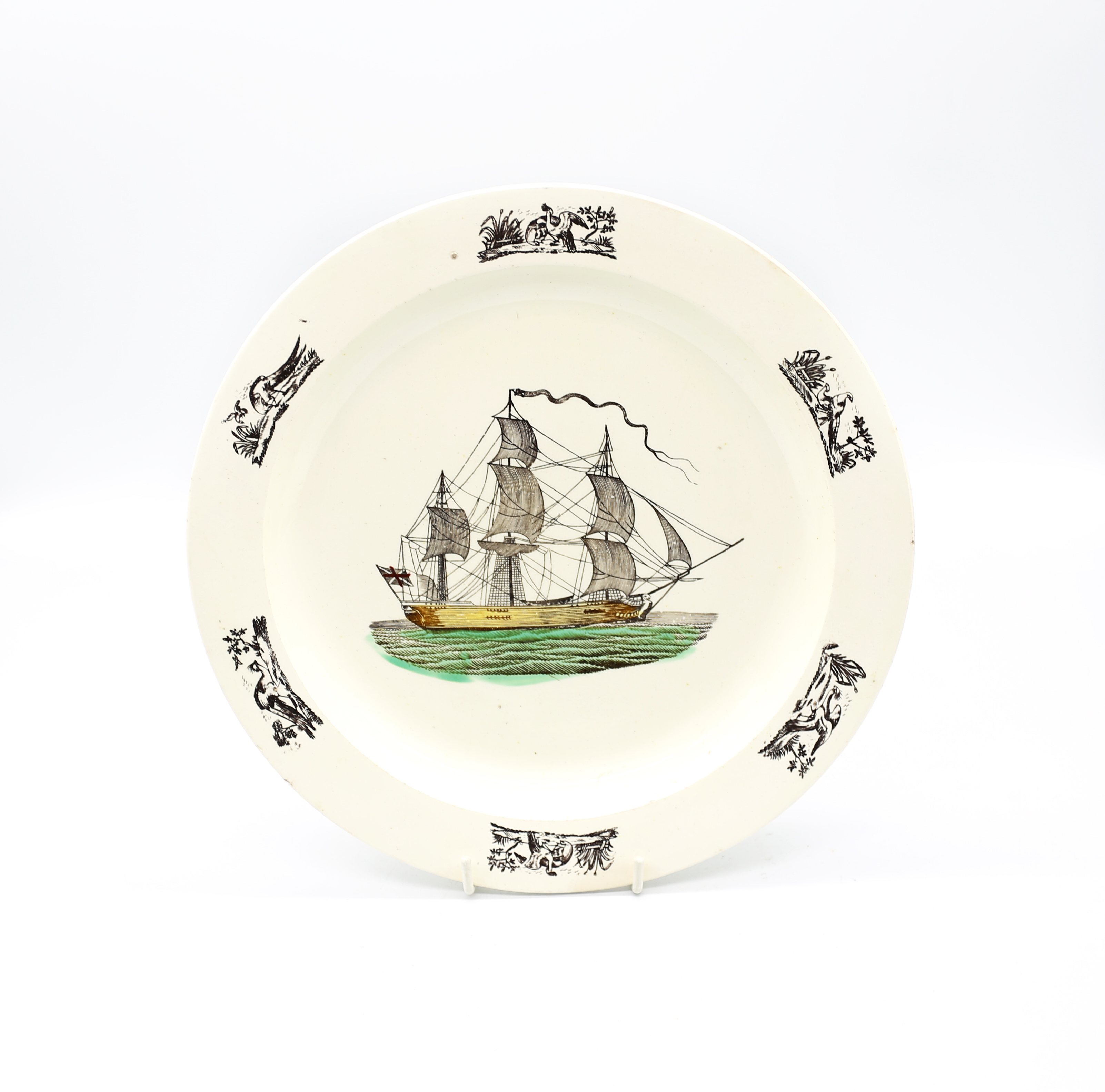 A late 18th century creamware plate, Liverpool, with a print of a war ship and birds printed in