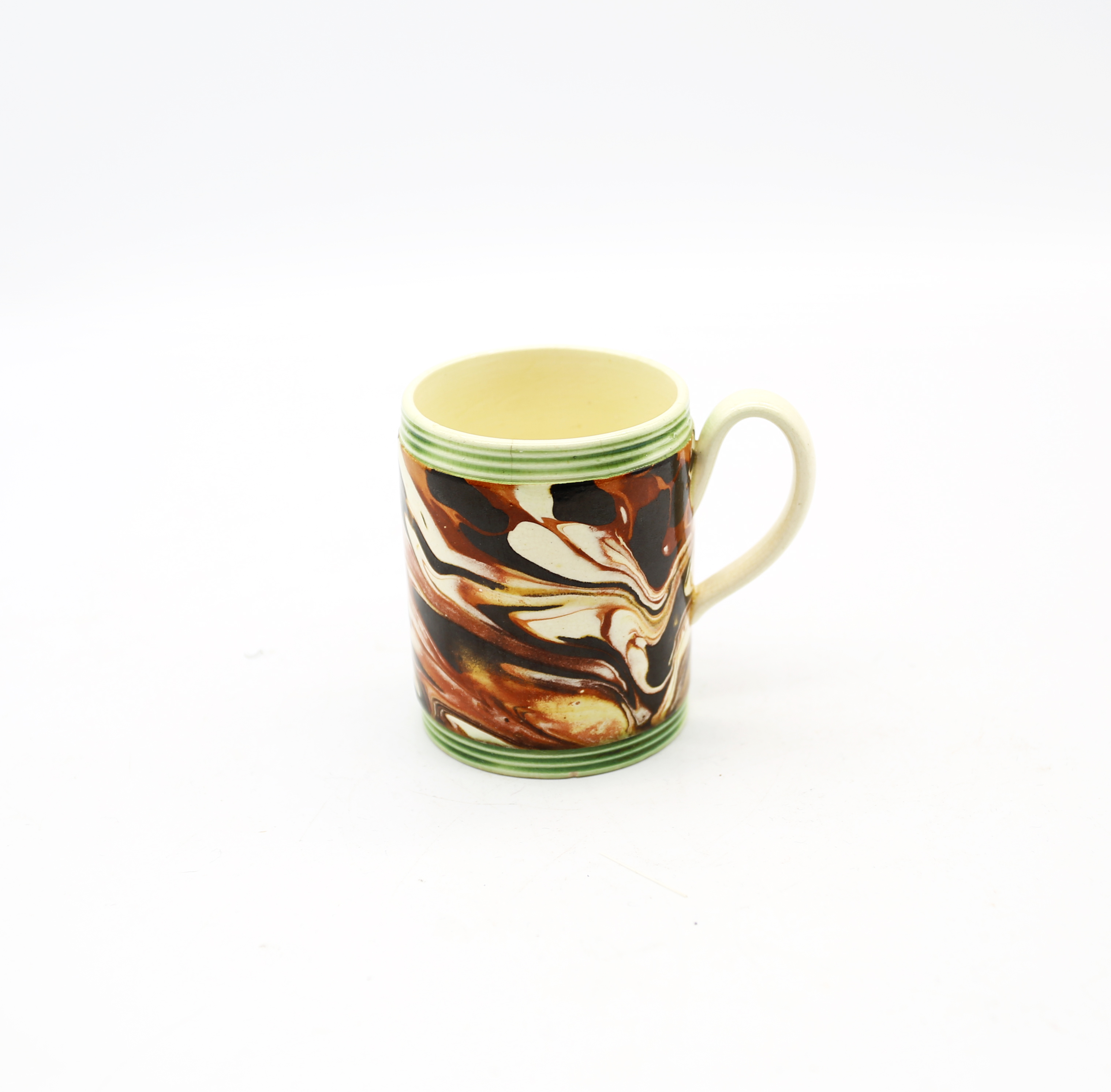 A small creamware cylindrical mug with coloured marbled decoration, with green ribbed bands to top