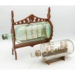 Two 19th century wooden models of Ship's in glass bottles; one encased in a light wooden frame of