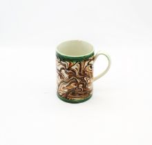 A creamware  cylindrical mug, brown, ochre and black marbled decoration with green ribbed bands to