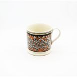 A large creamware mug, orange ground with a spattered finger trail design with  black  borders to