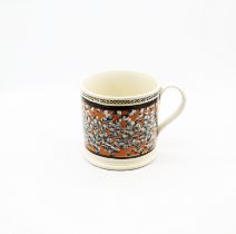 A large creamware mug, orange ground with a spattered finger trail design with  black  borders to