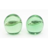 Two Victorian green glass domed paperweights, with sulphide fish designed centres, one slightly