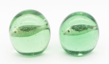 Two Victorian green glass domed paperweights, with sulphide fish designed centres, one slightly