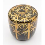 A 20th century Japanese black and gold lacquered tea cannister and cover, decorated with bamboo in