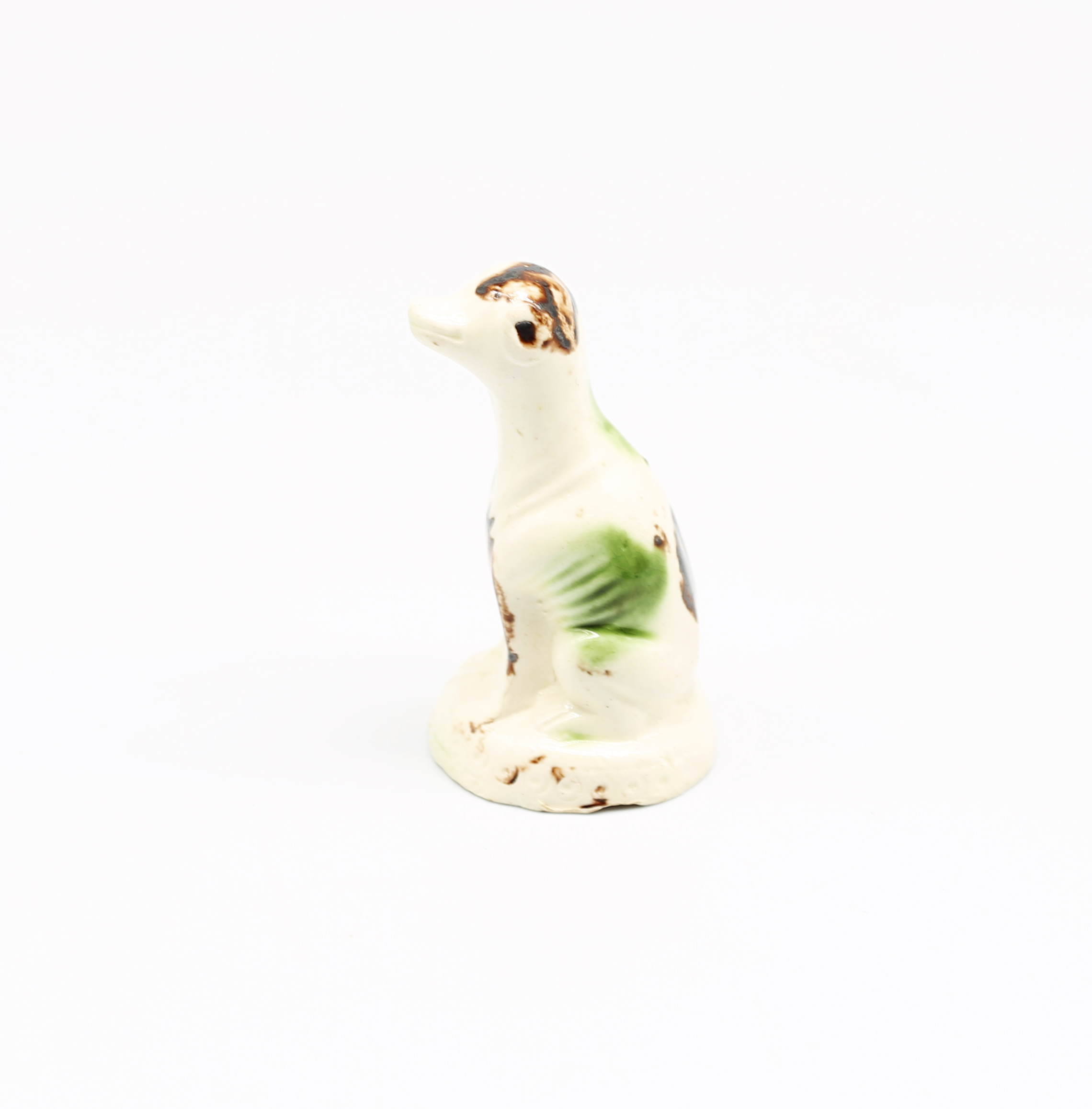 A Staffordshire creamware Whieldon style  model of a seated dog, sponge decorated in shades of green