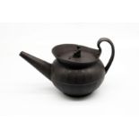 A Wedgwood black basalt teapot and cover with a flared lip.  The cover has a widow finial.