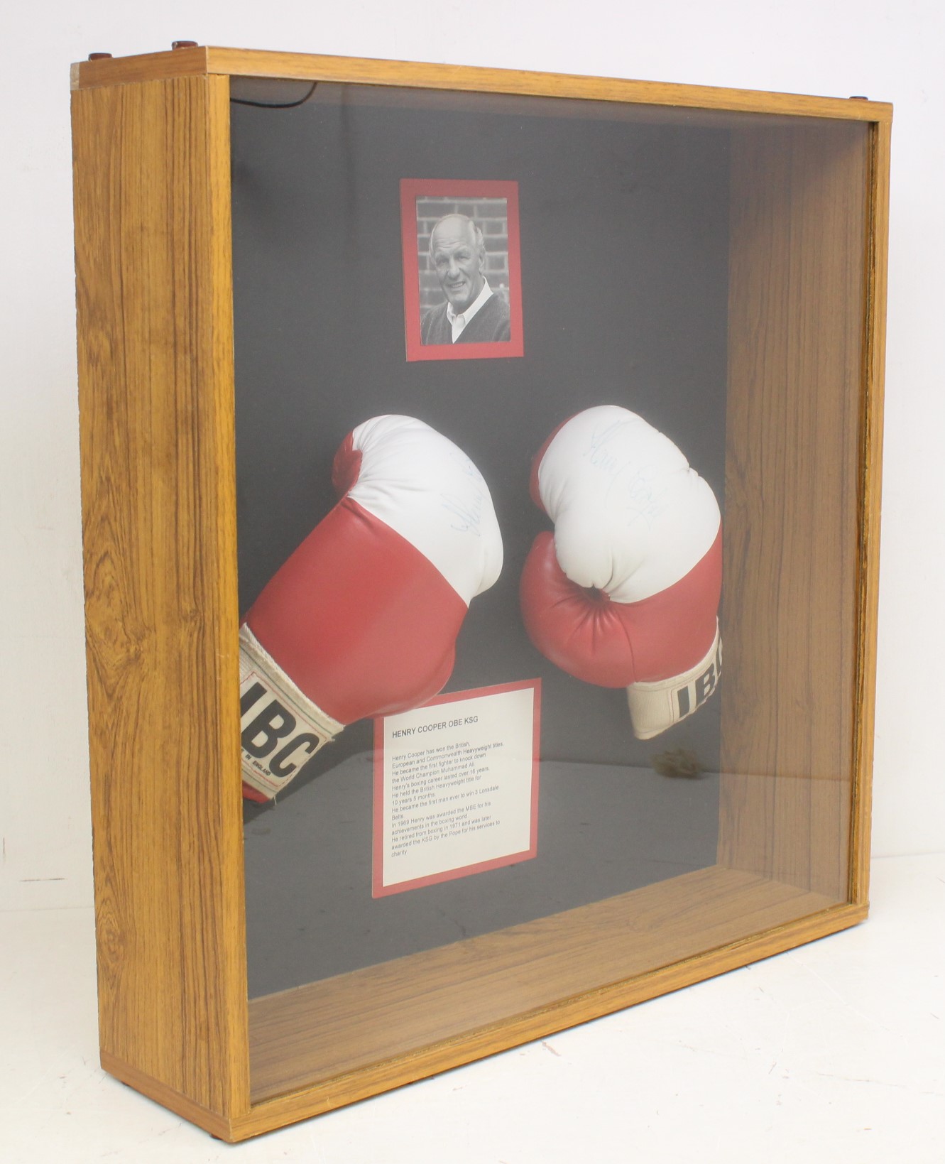 Boxing: A framed and glazed pair of signed Henry Cooper boxing gloves, signed by Cooper to both