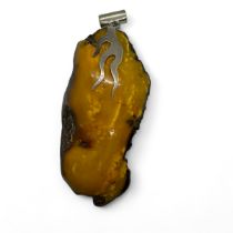 An egg yolk amber nugget pendant in sterling silver mount, formed from a huge piece of untreated