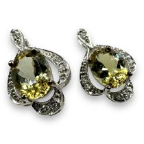 A pair of diaspore and white sapphire earrings, in white precious metal stamped 375. Testing as